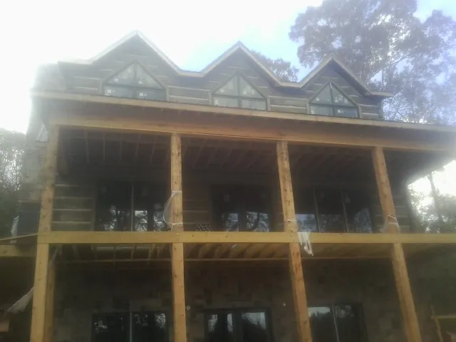 Dormers and porch framing on a large log home under construction — Roof Coating work by our crew in Wallowa