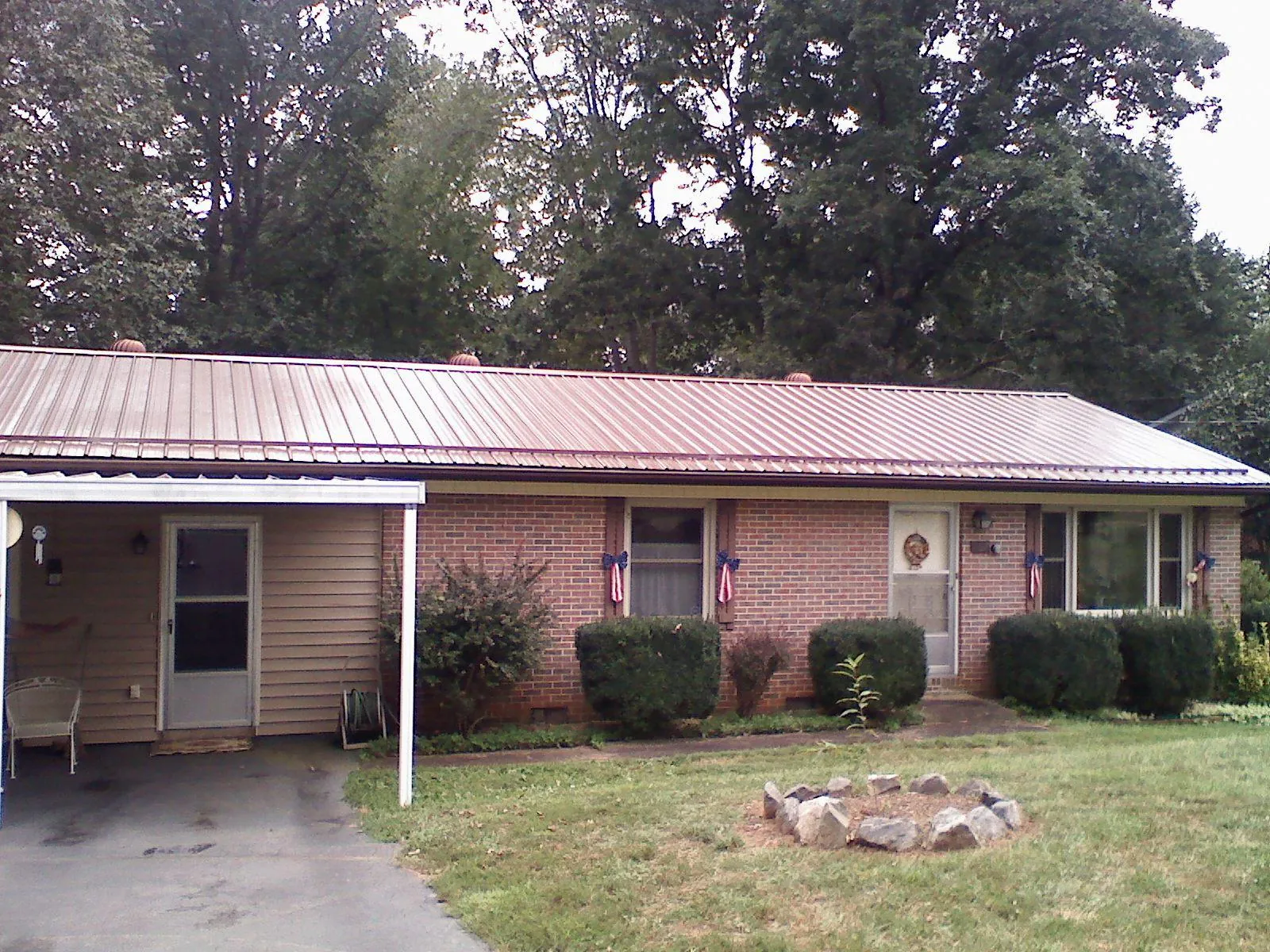 Bronze metal roof and carport on a brick ranch home — Roof Repair work by our crew in Wallowa